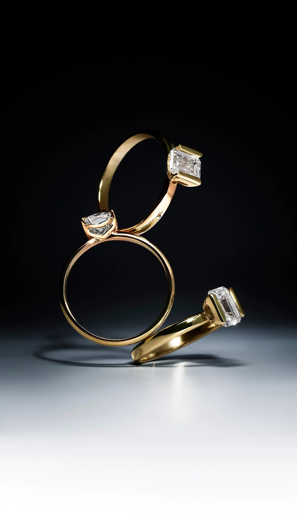 Three gold rings with lab-grown diamond accents on a dark background